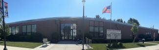 Front of the library building on a sunny day with a blue sky